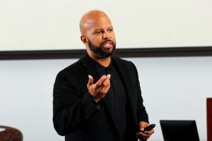 Christen Thomas standing in front of a podium and speaking