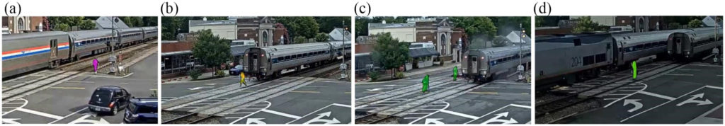 Image of computer vision tool detecting pedestrians on tracks as train is actively using intersection, they are shown highlighted in green