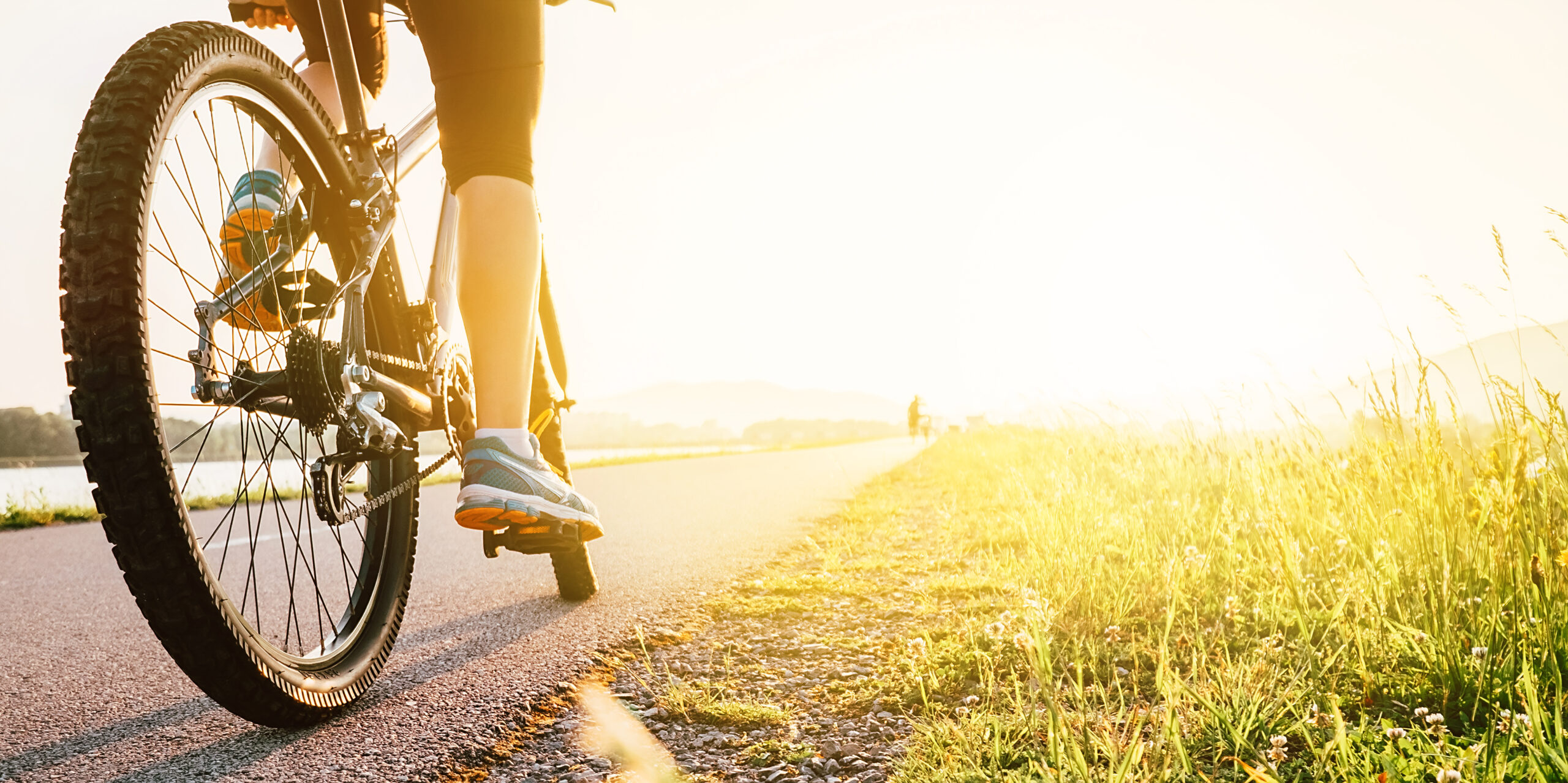 Woman feet on bycikle pedal in sunset light