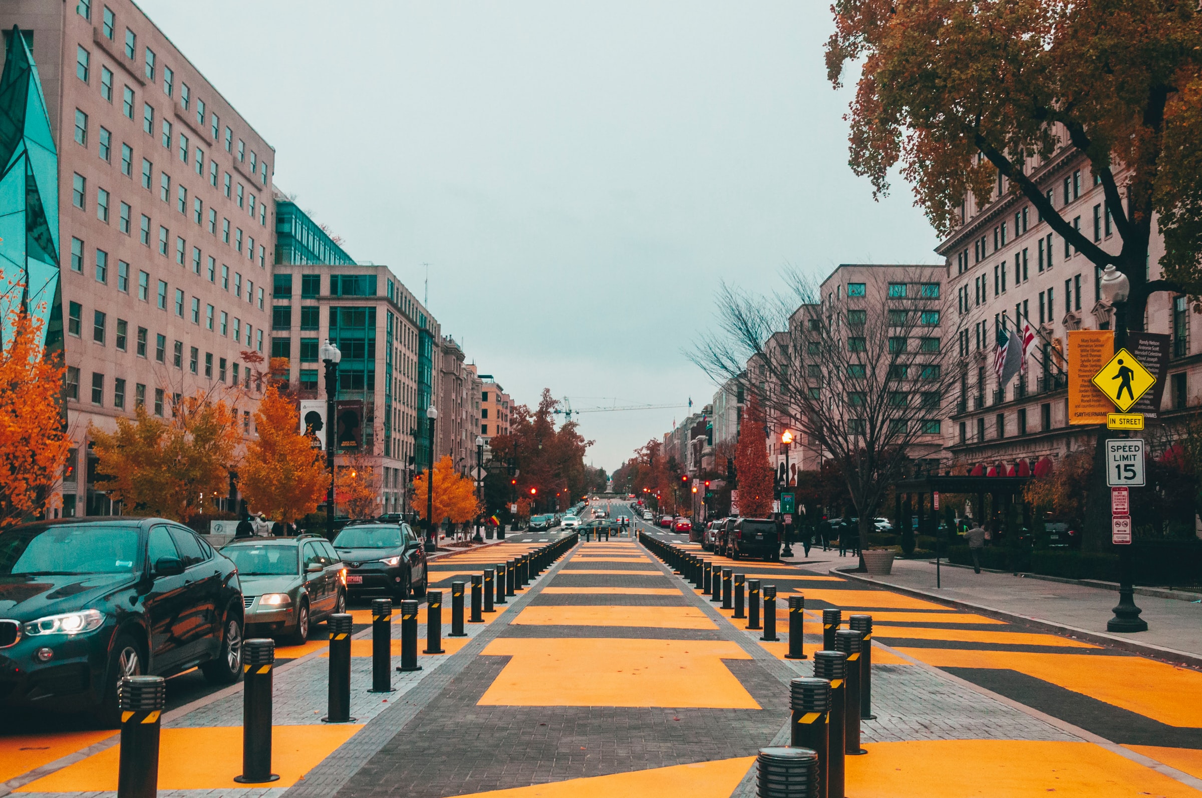 A “complete street” in Washington, D.C. with several community livability features for an urban setting such as wide sidewalks with tree coverage, traffic calming design, and a physically protected middle bike lane.  Photo by Maria Oswalt on Unsplash.