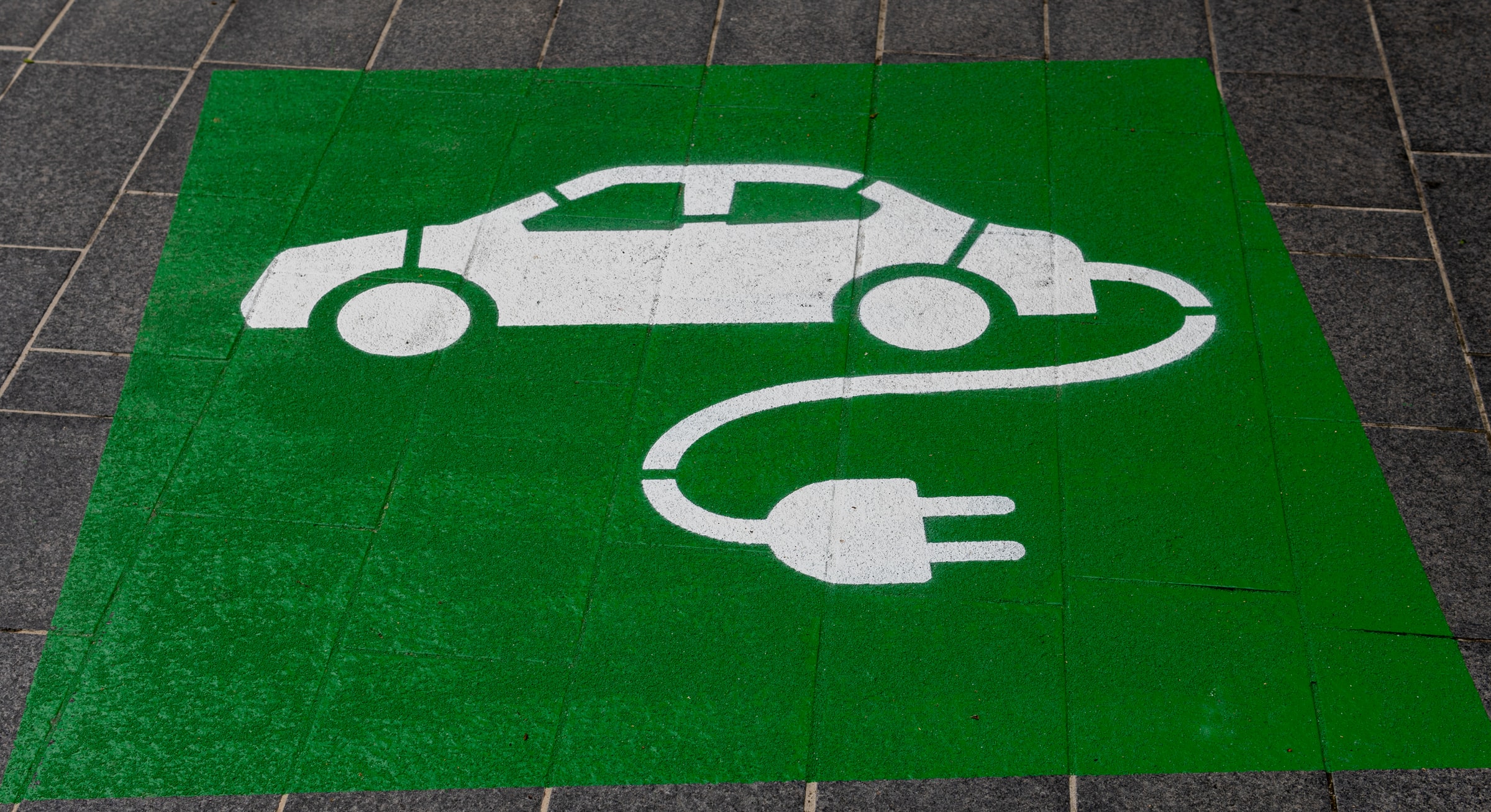 Charging Station sign: Increased investments in EV charging technology will promote changes in built environment and the energy mix of transportation.  Photo by Michael Marais on Unsplash.